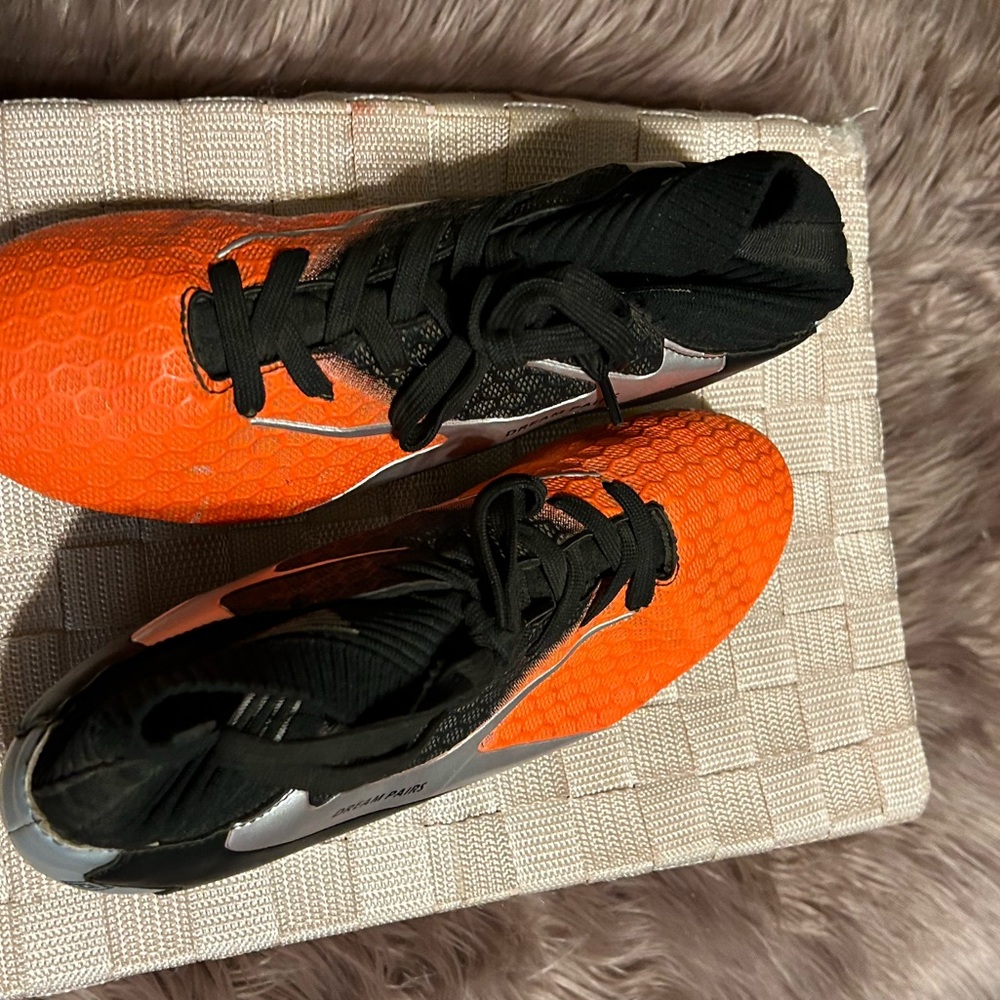 Orange and black cleats size 6